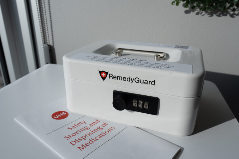 A white medication lockbox with a brochure on safe medication disposal
