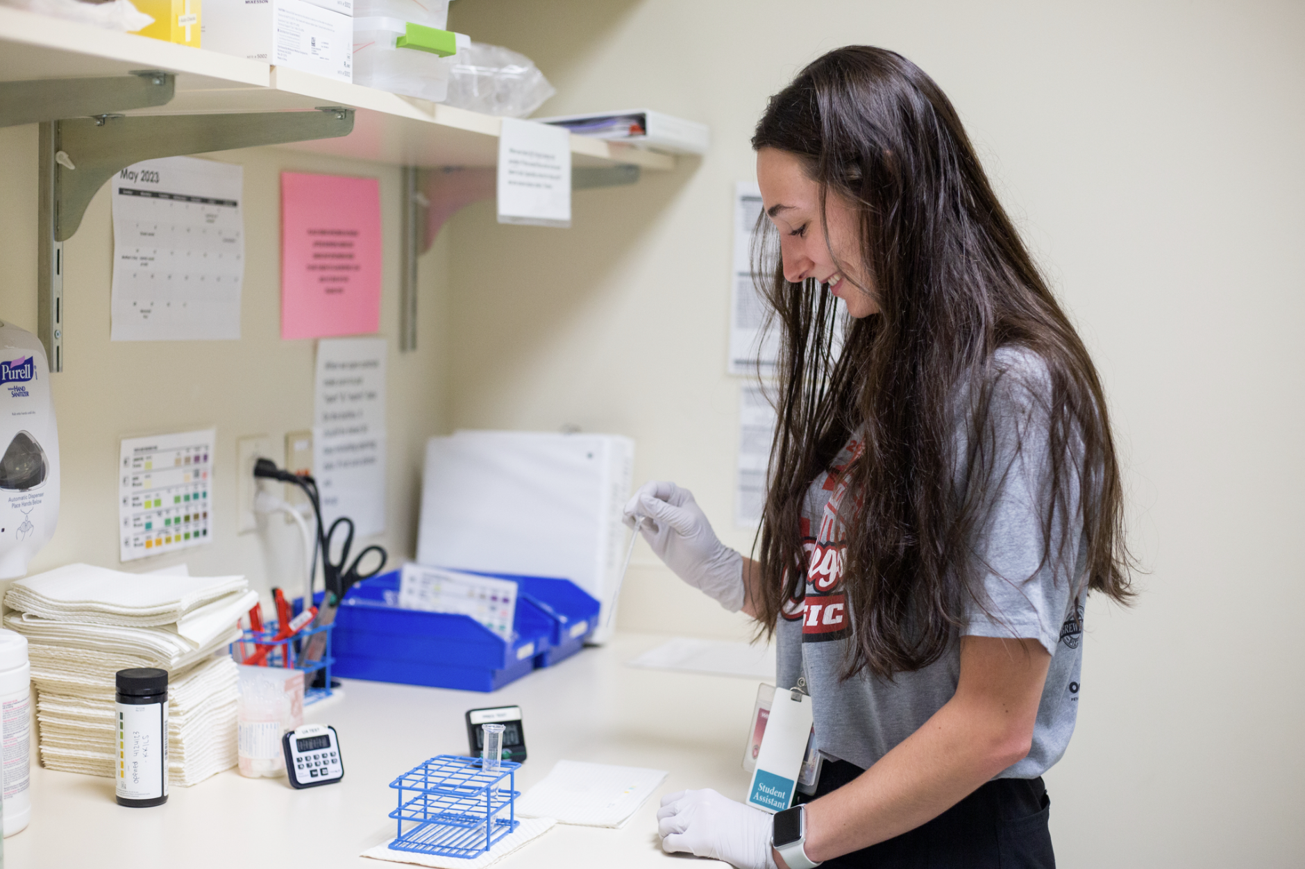 A student health assistant works with a sample