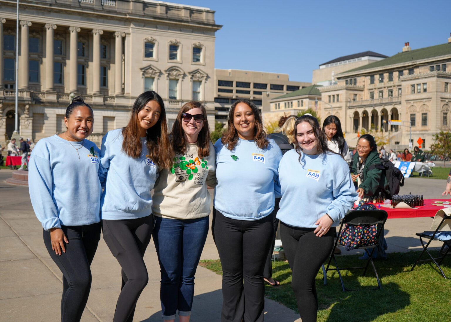 Students of Mental Health Student Advisory Board stand and smile with their advisor at the mental wellbeing resource fair.
