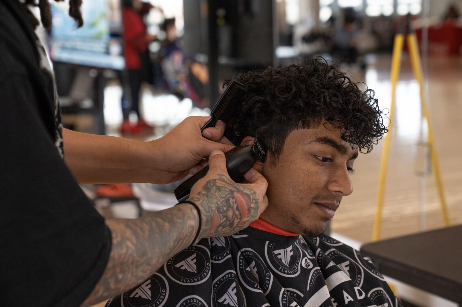 Student getting their haircut in the barber chair.