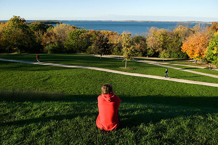 Student sits on observatory hill grass.