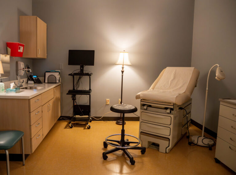 Sexual Assault Forensic Exam room located on the 7th floor of UHS featuring a medical table, lamp, and provider chair