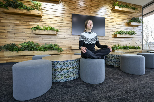 A professional intern in a criss-cross pose in the Willow Room at the Bakke Recreation and Wellbeing Center