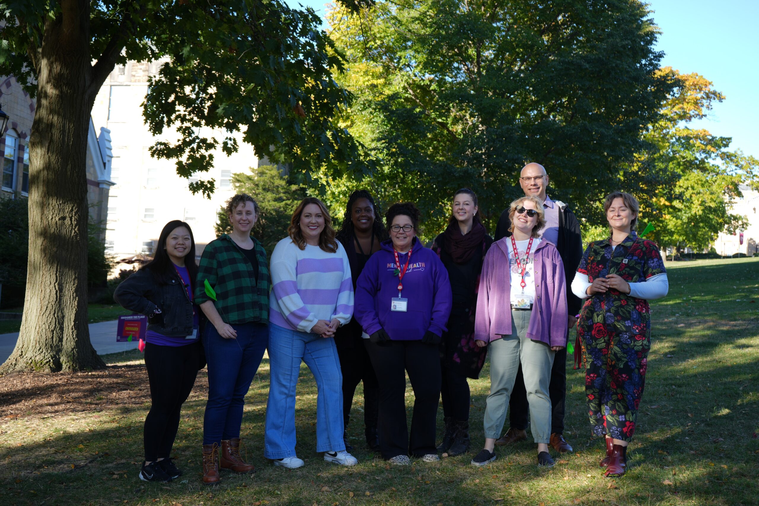 Survivor Services staff members standing next to each other smiling on Purple Thursday during Domestic Violence Awareness Month.