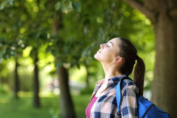 Profile of a student breathing fresh air in a campus or park