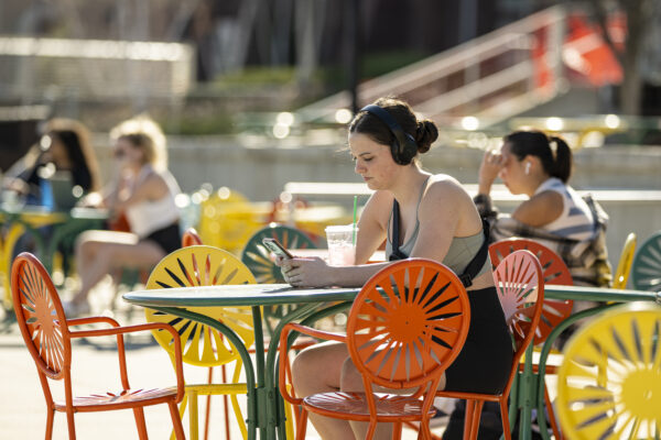 Undergraduate Sami Lacke is one of the first students to take advantage of the chairs as movers and volunteers begin to unload truckloads of iconic Terrace chairs, previously stored for the past winter, and distribute them at the Memorial Union Terrace