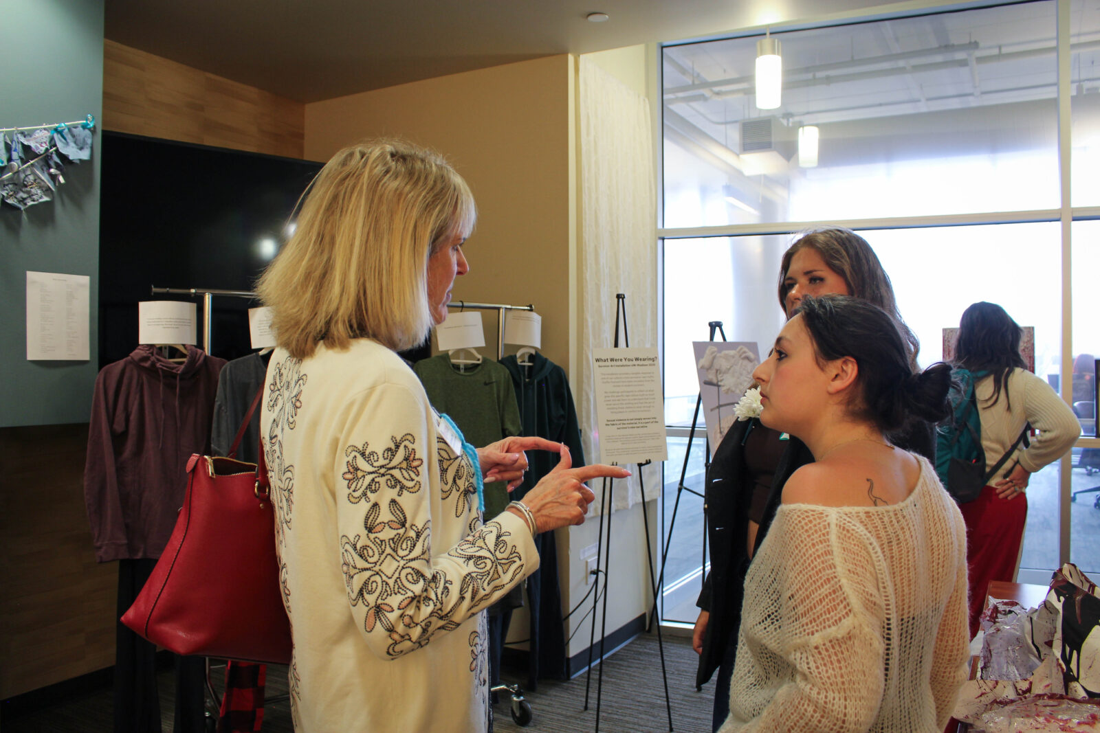Vice Chancellor of Student Affairs, Lori Reesor speaks with student survivor artists during the Closing Reception.