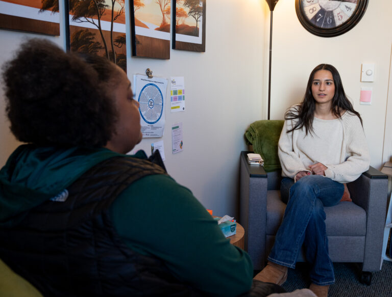 Student seated across from a mental health provider.