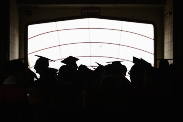 Pictured in silhouette, soon-to-be-graduates enter the stadium stadium tunnel before the start of UW-Madison's spring commencement ceremony.
