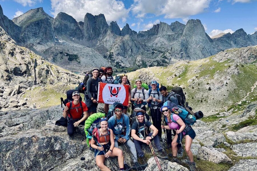 Wisconsin Hoofers students smile together on top of a mountain.